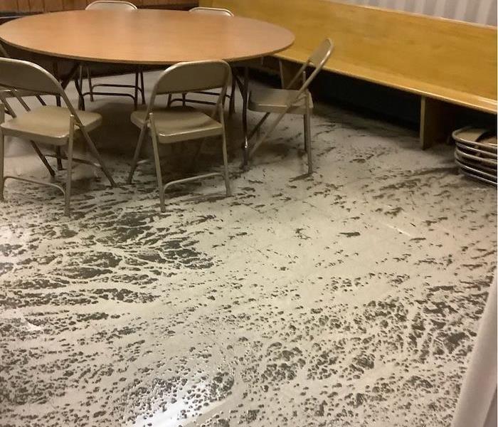 Cafeteria with sewage on floor around tables