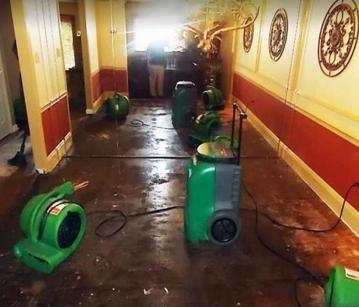 water damaged hallway of commercial building;l SERVPRO restoration equipment being used