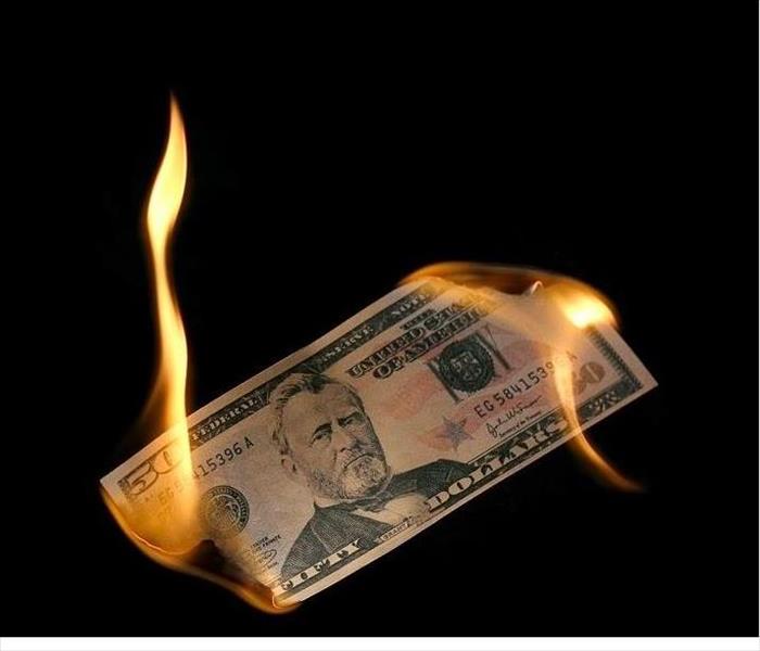 fifty dollar bill being burned at both ends