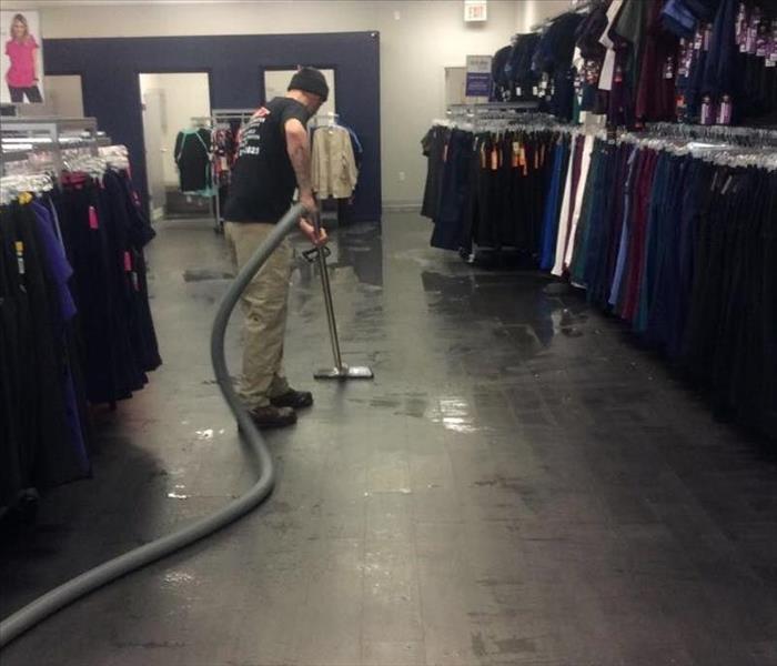 A man cleaning the floor of a business. 